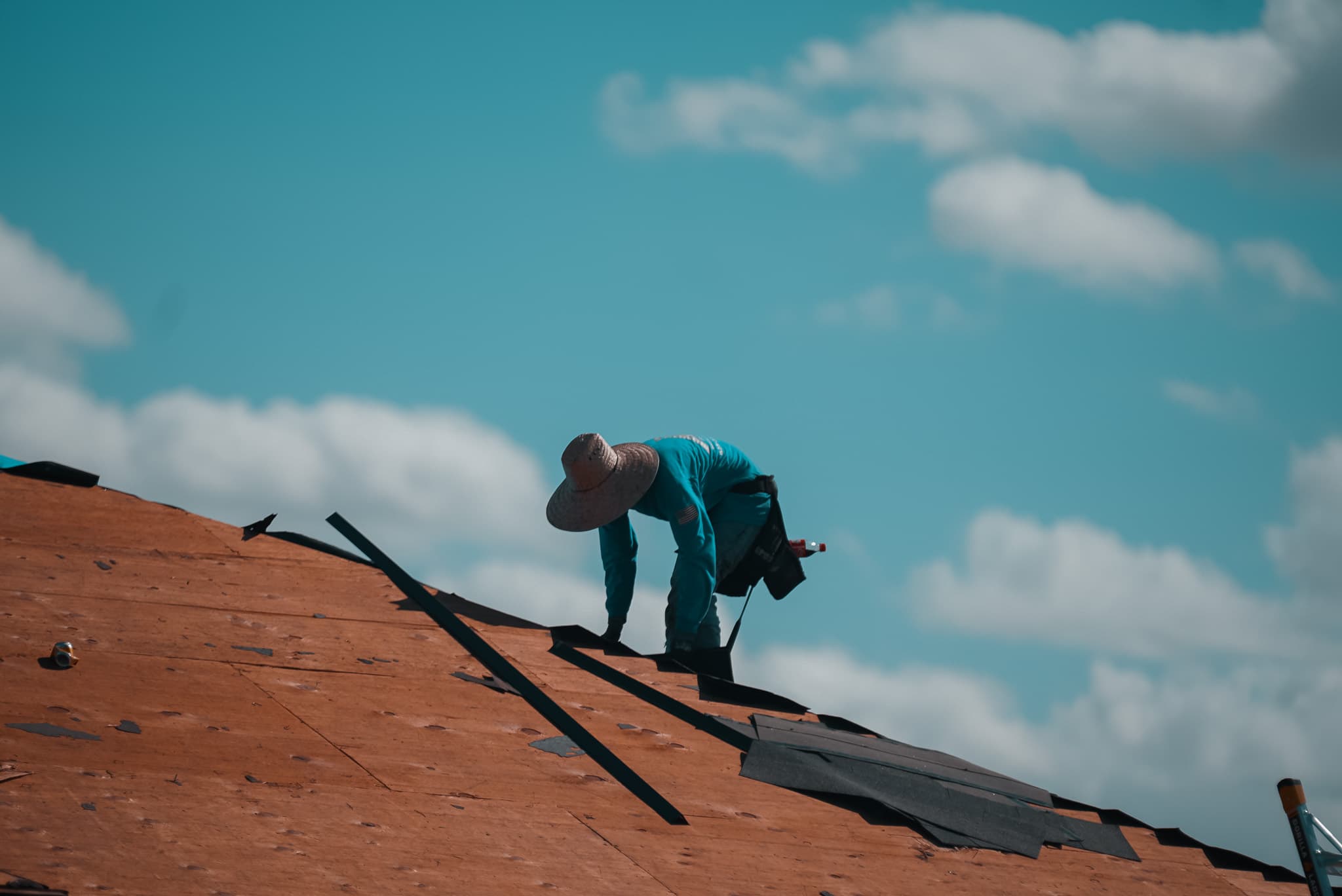 HailCo Roofing crew member on bare decking during a Phoenix Valley roof repair diagnostic